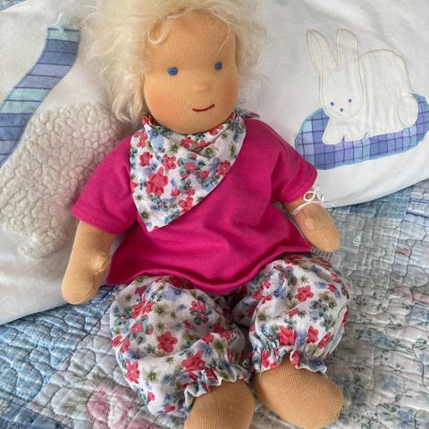 Blonde Schlenkerpuppe in pinkem Shirt mit geblümtem Halstuch und geblümter Hose