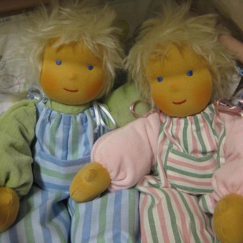 Zwei blonde Schlenkerpuppen in gestreiften Latzhosen