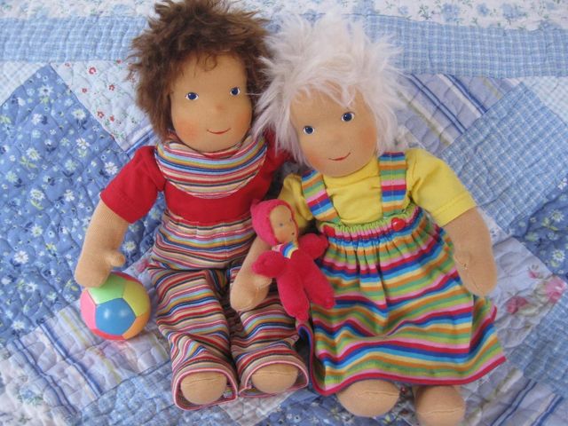 Zwei Schlenkerpuppen in Ringelhose und Ringelrock mit Ball und rotem Püppchen