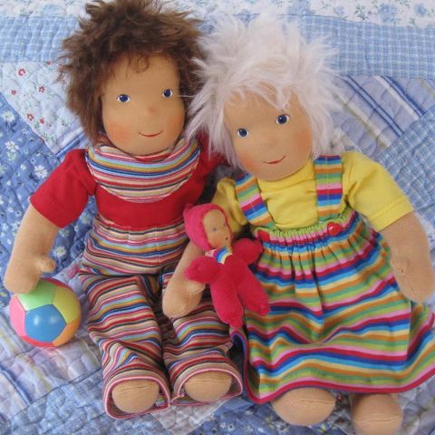 Zwei Schlenkerpuppen in Ringelhose und Ringelrock mit Ball und rotem Püppchen